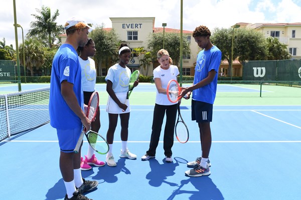 Chris Evert on a tennis court talking to NJTL youth.