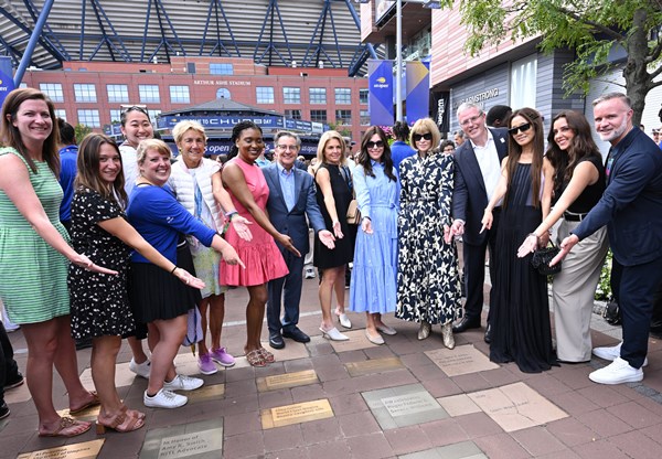 Ginny Ehrlich of the USTA Foundation, Cheryl Scharf, Anna Wintour, David Scharf, Vera Wang, Kasey O'Connor, Lori Ogden, Sara Rizzi, Yuki Chiang, Missie Rennie, Molly John, Ben Doller, Kim Borza Donaldson, Robert Howland and members of the USTA Foundation at the paver ceremony for Anna Wintour on the Avenue of Aces at the 2024 US Open. © Jennifer Pottheiser/USTA