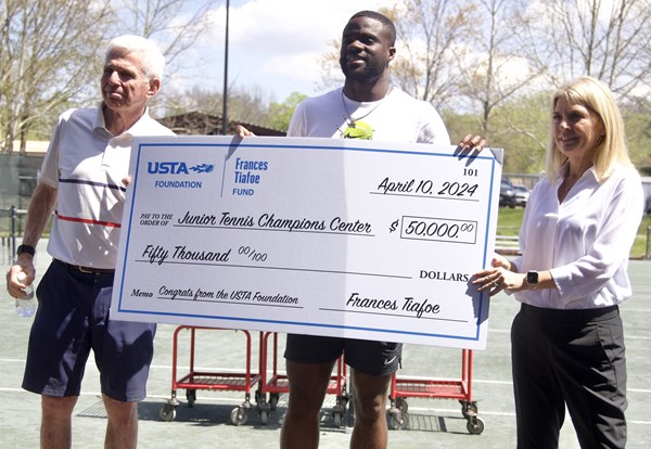 Frances Tiafoe presenting a check to JTCC with USTA Foundation CEO Ginny Ehrlich.