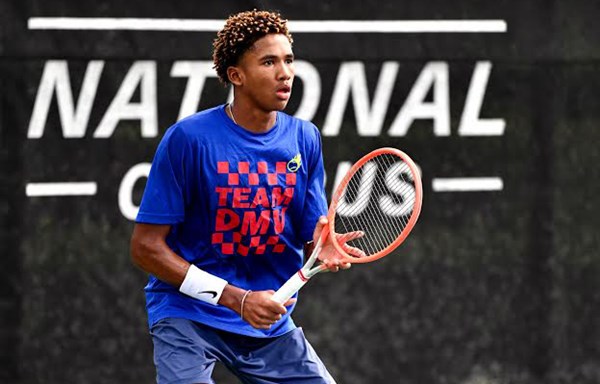 Vander Woody holding a tennis racquet focused mid-match at the USTA National Campus.