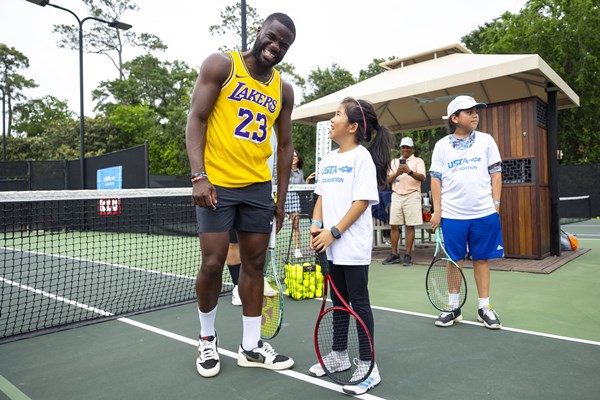Frances Tiafoe at the Frances Tiafoe Fund clinic in Houston on the court smiling with a youth player