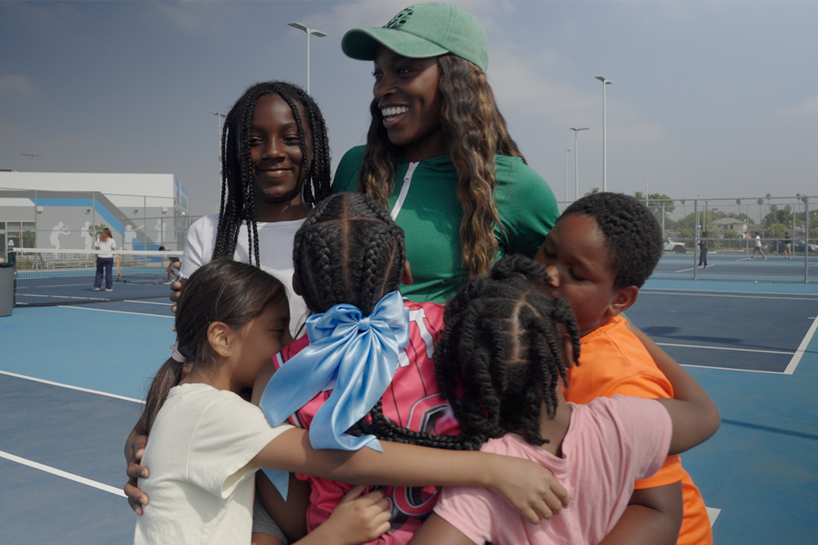 Sloane Stephens with young tennis players on court.