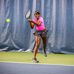 Teenage tennis player hitting backhand